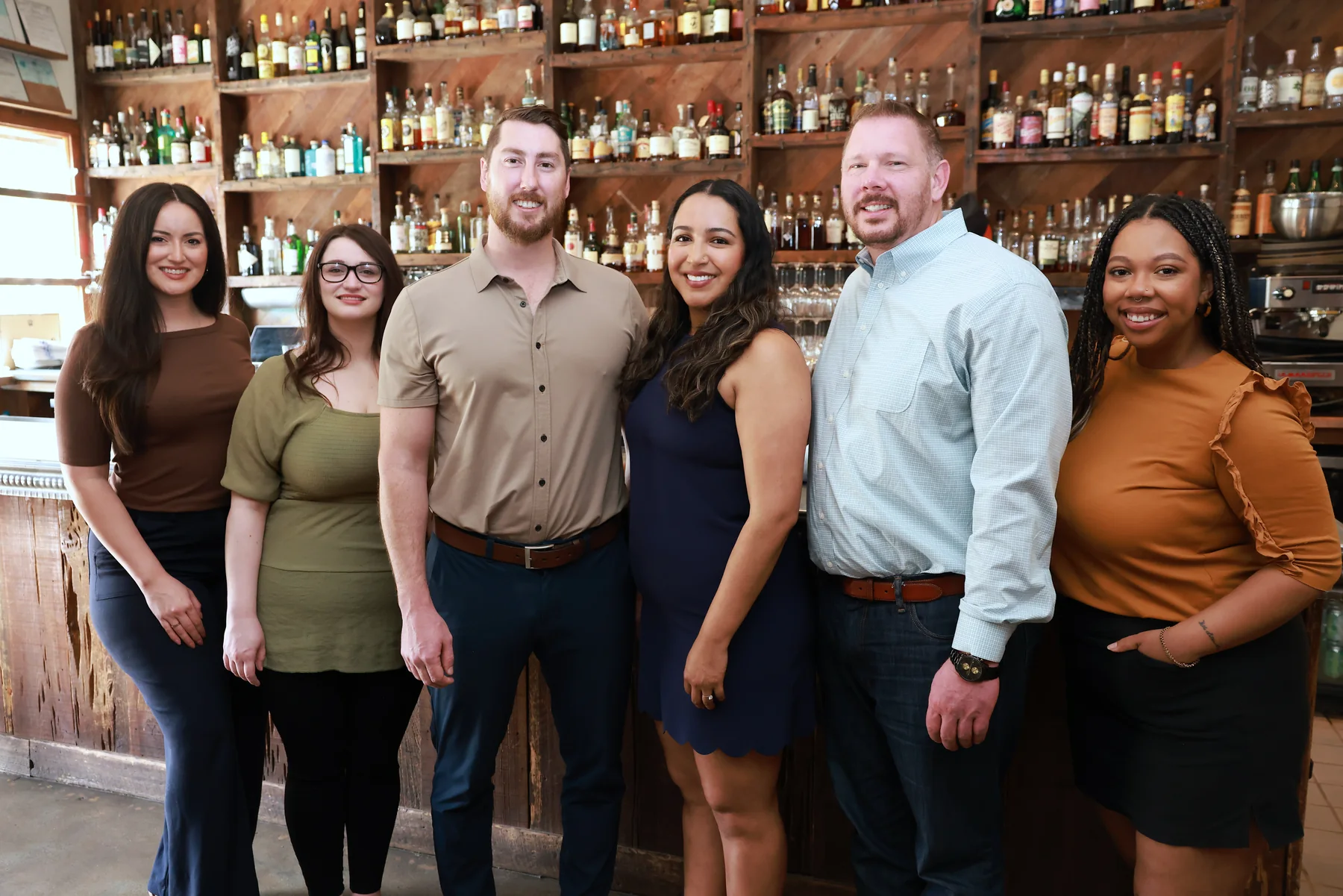 Manucci Financial team standing together in a restaurant bar.